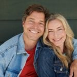 Woman and man over 50 smiling into camera as a couple