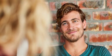 A man making eye contact with a woman.