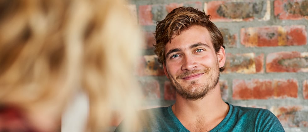 A man making eye contact with a woman.