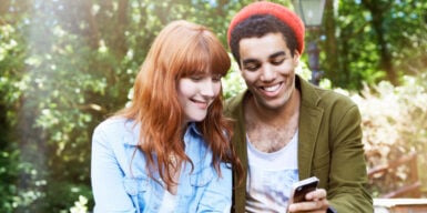 Woman and man looking at a cell phone together as a symbol of dating preferences