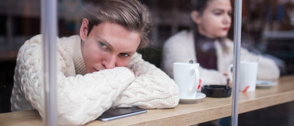 Woman looks thoughtfully out of the window and wonders why online dating doesn't work