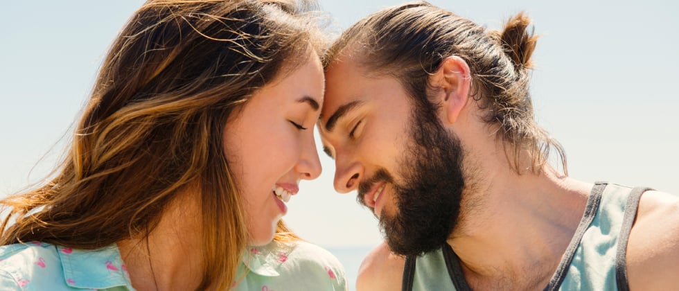 A woman and a man touching their foreheads, initiating physical touch as love language