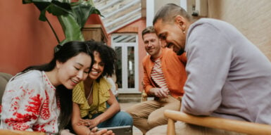 a group of people sitting and looking at a phone together