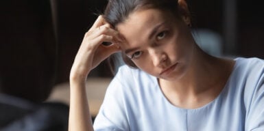 A woman looking annoyed while her head rests on her fist