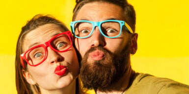 A couple being goofy wearing multi-colored glasses