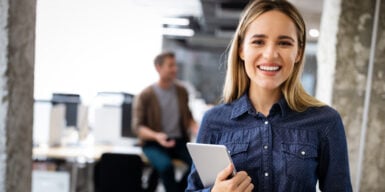 A woman standing with an iPad in a corporate office